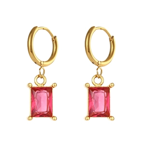 Macro detail of gold hoop earrings with rectangular pink zircon gemstone pendants