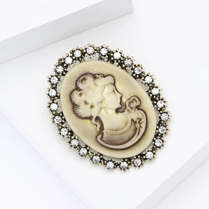 Vintage relief brooch with crystal rhinestones and lady silhouette in bronze frame