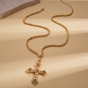 Détail de collier croix baroque vintage avec pierres multicolores et chaîne en or style corde
