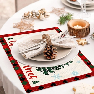 Close-up of Christmas placemat with red plaid and tree print on a white dining table