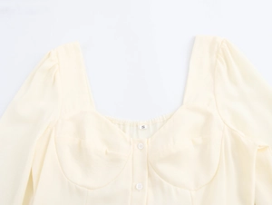 Close-up of light yellow French square neck dress with puff sleeves and front buttons