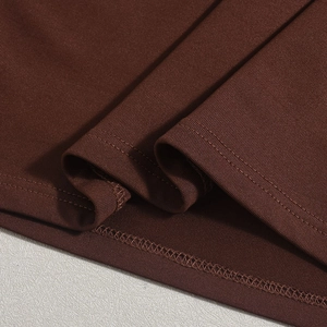Detaillierte Makroansicht des kaffeebraunen Strickkleides mit hochwertiger Saumnaht