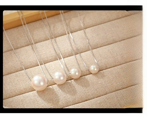 Macro comparison of four S925 silver pink pearl necklace sizes on a soft jewelry tray
