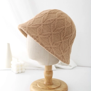 Stylish camel knit bucket hat with textured floral pattern on a professional display stand