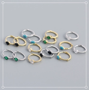 Macro detail of S925 silver twist rope huggie earrings with colorful teardrop gemstones