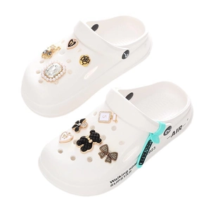 White platform clogs with DIY charms including black bears and golden flowers