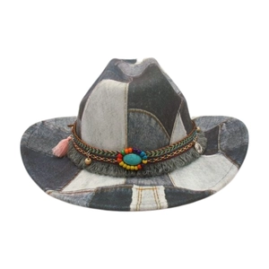 Detail of patchwork denim cowboy hat with turquoise stone and colorful fringe accents
