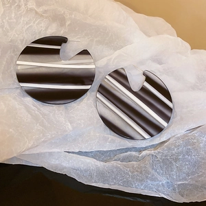 Chic black and white striped acrylic hoop earrings with a geometric round design