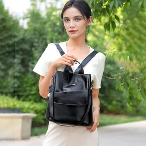Detail of black geometric leather backpack featuring gold hardware and adjustable straps
