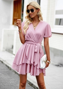 Détail de la robe rose en coupe A avec col en V, lien à la taille et jupon volanté