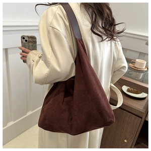 Brown suede tote bag shown on model shoulder with minimalist design for daily use