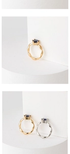 Detail of twisted rope band ring with round blue gemstone in four-prong setting