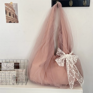 Detail of pink mesh hobo bag with delicate white lace flower bow and layered fabric