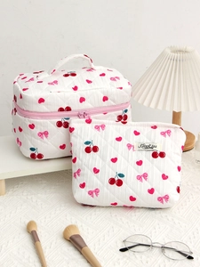 Detailed close-up of quilted cotton cosmetic bag set with cherry and bow patterns