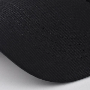 Close-up of black cotton twill baseball cap brim showing precise parallel stitching detail