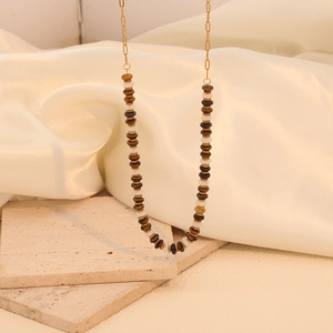 Detail of beaded necklace with brown tiger stone and white pearls on gold chain