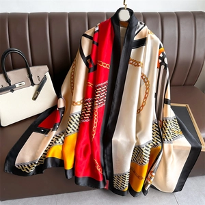 Elegant large silk scarf featuring red chain and equestrian patterns as a draped shawl