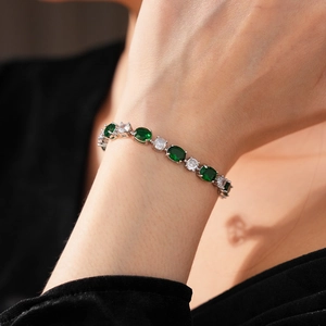 Bracelet en argent avec pierres ovales vertes et zircons porté au poignet gros plan