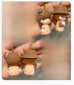 Detailed side and back view of cartoon couple keychain charms with matte texture
