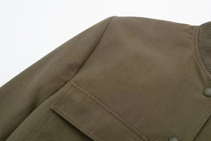 Detail of army green bomber jacket fabric with stand collar and double-stitched pockets