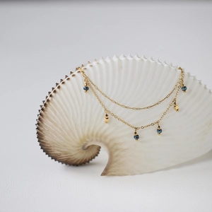 Double-layered 18K gold plated titanium necklace with vintage blue beads on a seashell
