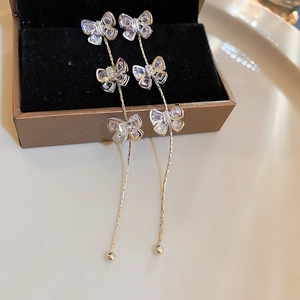 Détail de boucles d'oreilles nœud en argent avec glands papillon sur boîte à bijoux