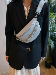 Light blue half-moon crossbody bag with silver chain detail on model in black suit