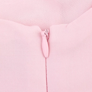 Close-up of pink invisible zipper and textured fabric detail on a striped mini dress