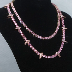 Detailed view of pink gemstone tennis chain with rose gold spike pendants on neck model