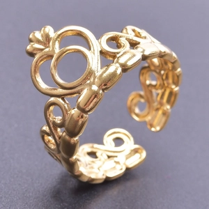 Elegant gold crown ring with hollow patterns on a minimalist black background