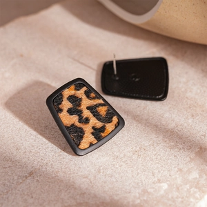 Detailed macro view of vintage leopard print faux leather trapezoid earrings with matte frames