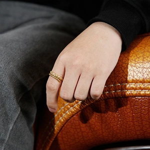 Close-up of golden octopus tentacle ring with suction cup texture on little finger
