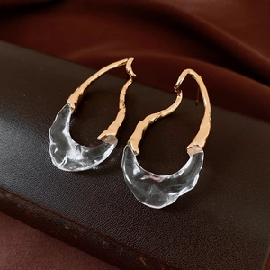 Dettaglio macro di orecchini placcati oro 18k con resina irregolare e perni in argento