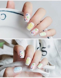 Detail of gummy bear nail stickers with colorful candy lines on white base coat