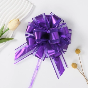 Detail of a purple organza and plastic pull bow for elegant gift box packaging