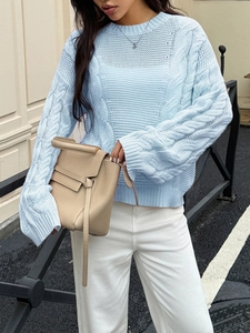 Detail of light blue knit sweater featuring a classic cable stitch texture and crew neck