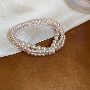 Close-up of elegant double-layer pearl bracelet with a sparkling rhinestone center clasp