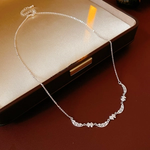 Detail of silver bow necklace with adjustable clasp on premium brown leather surface
