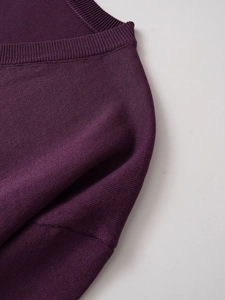 Vista dettagliata della trama del tessuto a maglia fine viola prugna e bordo a costine