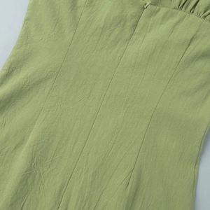 Detail of the hidden zipper and pleated texture on the back of the grass green cotton dress
