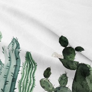 Macro view of white fabric tapestry featuring detailed watercolor cactus and succulent patterns