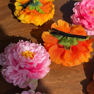 Detailed view of artificial peony hair clips with silk petals and black metal base