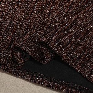 Makro-Detail des gestreiften Stoffes in Bronze und Schwarz mit Metallic-Garn und Pailletten