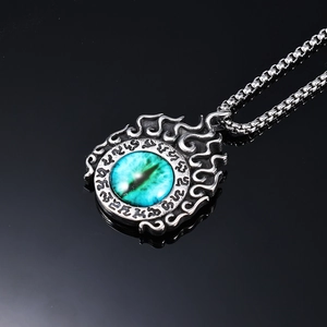 Gothic evil eye pendant necklace in vintage silver with blue stone on black surface