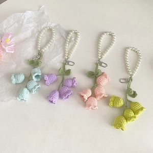 Detail of colorful crochet lily of the valley keychains with pearls and metal clips