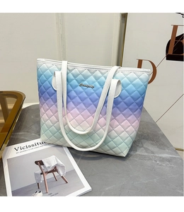 Detailed close-up of gradient tote bag with diamond pattern and gold brand logo