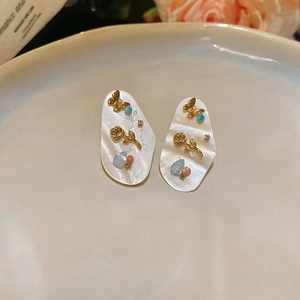 Vue détaillée de boucles d'oreilles vintage en nacre avec motifs floraux et cristaux