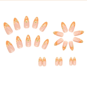 Cute almond press-on nails with nude pink base, orange French tips, and yellow smiley faces