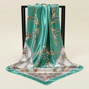 Detailed close-up showing silky texture and lily of the valley floral print on square scarf