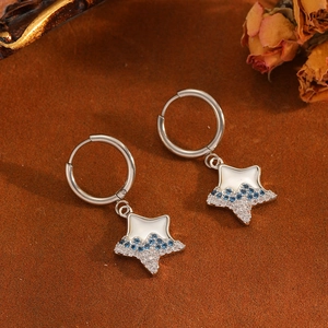 Detail of silver star earrings with white mother-of-pearl and blue sparkling crystals